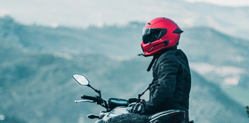 a man riding a motorcycle with a mountain in the background