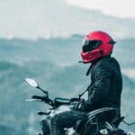 a man riding a motorcycle with a mountain in the background