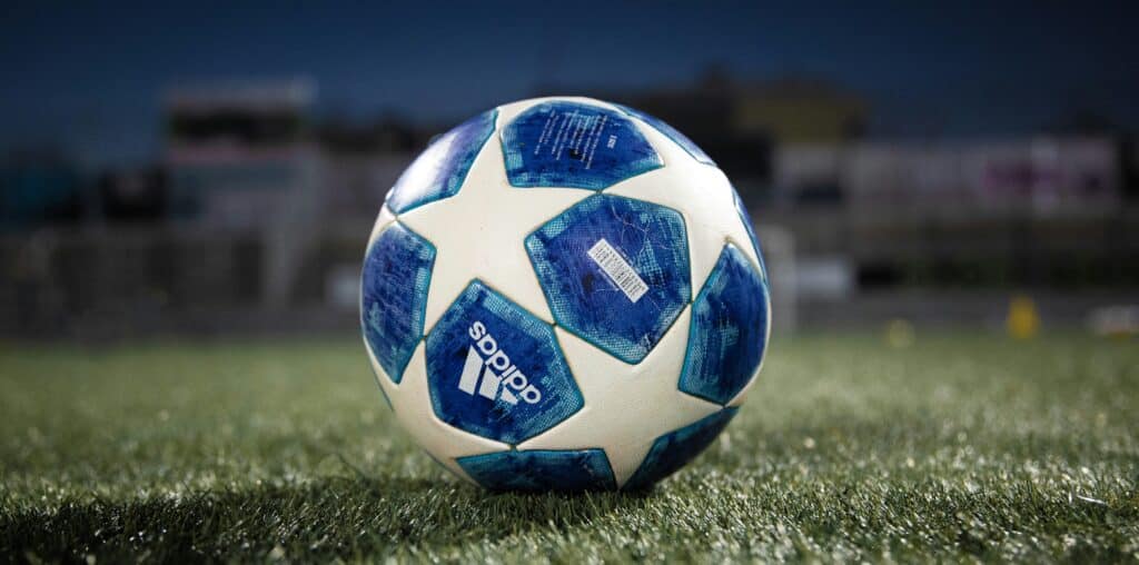 white and blue soccer ball on green grass field